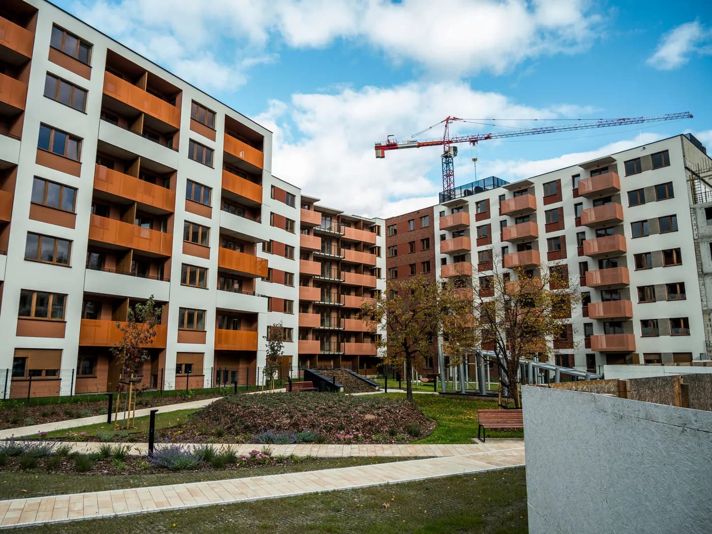 New residential apartment development with landscaped shared space and a construction crane